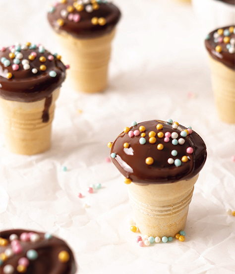 Cupcakes im Waffel-Becher mit Schokoladenglasur und bunten Streuseln